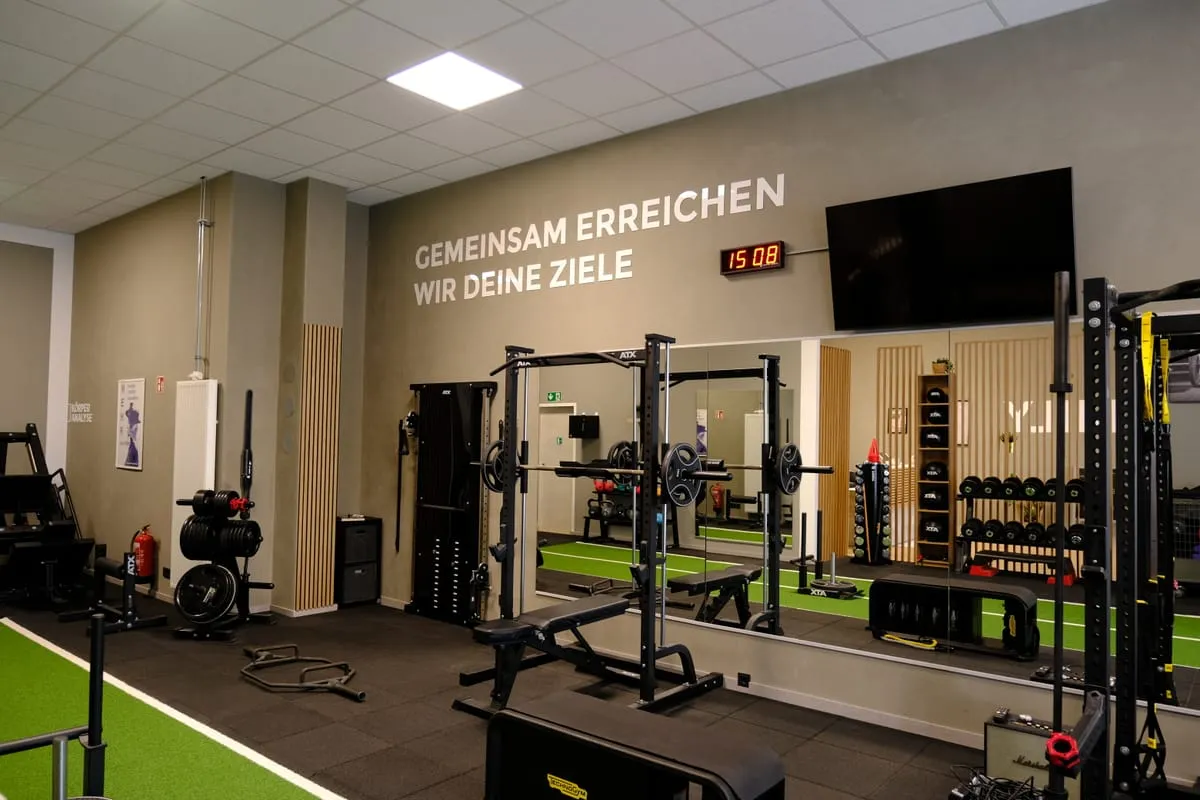 Trainingsfläche mit Rack, Hanteln und Spiegelwand